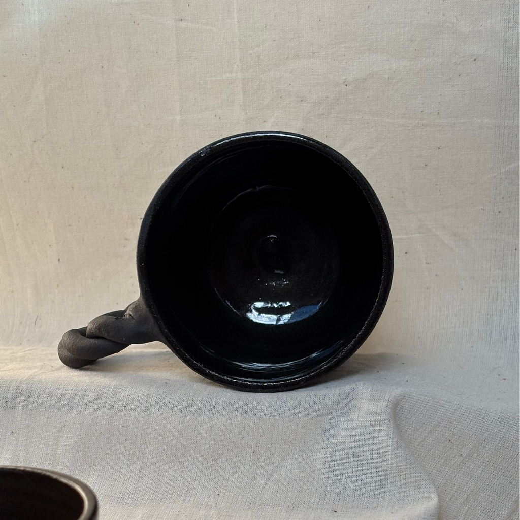 The inside of a black mug showing the glazed surface on the inside