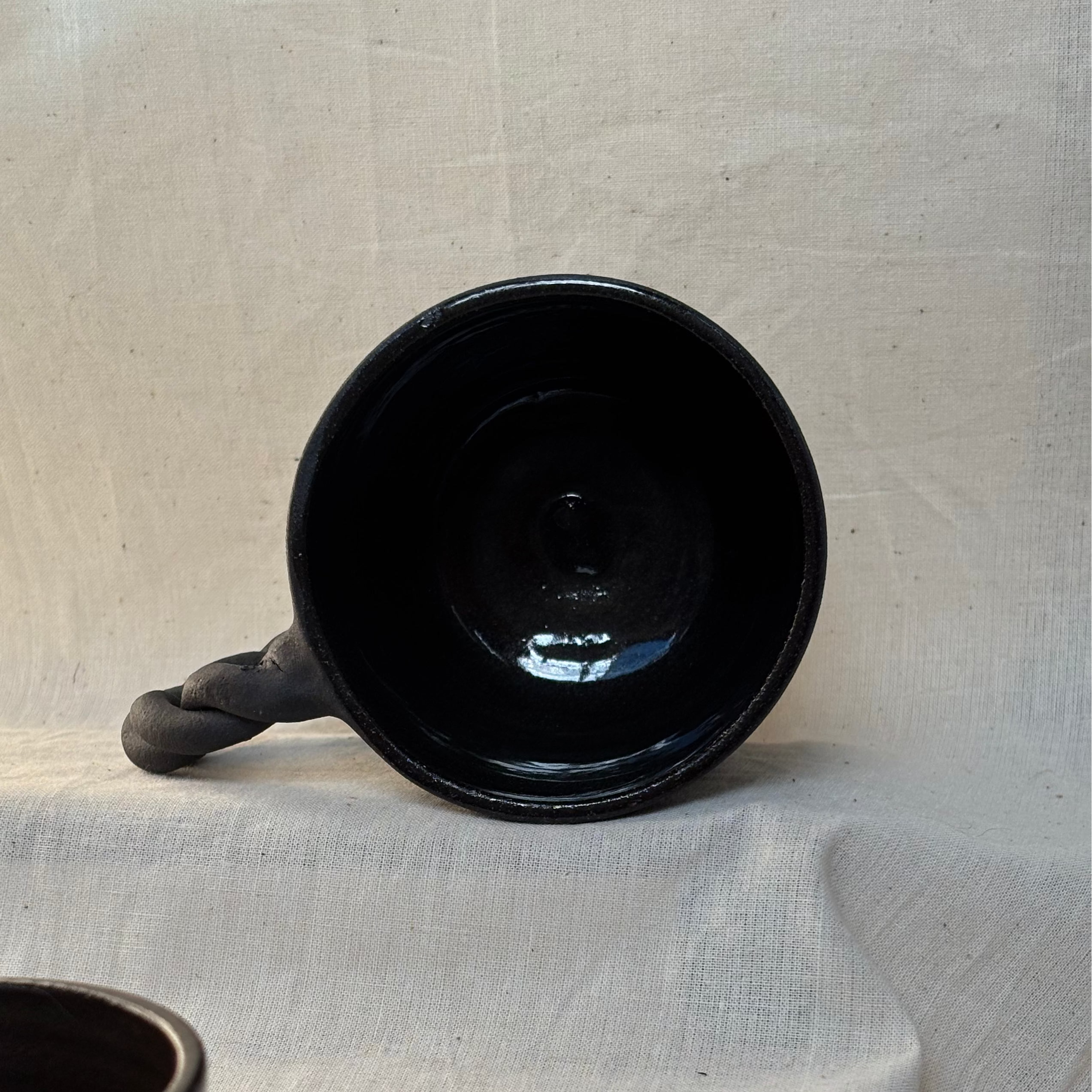 The inside of a black mug showing the glazed surface on the inside