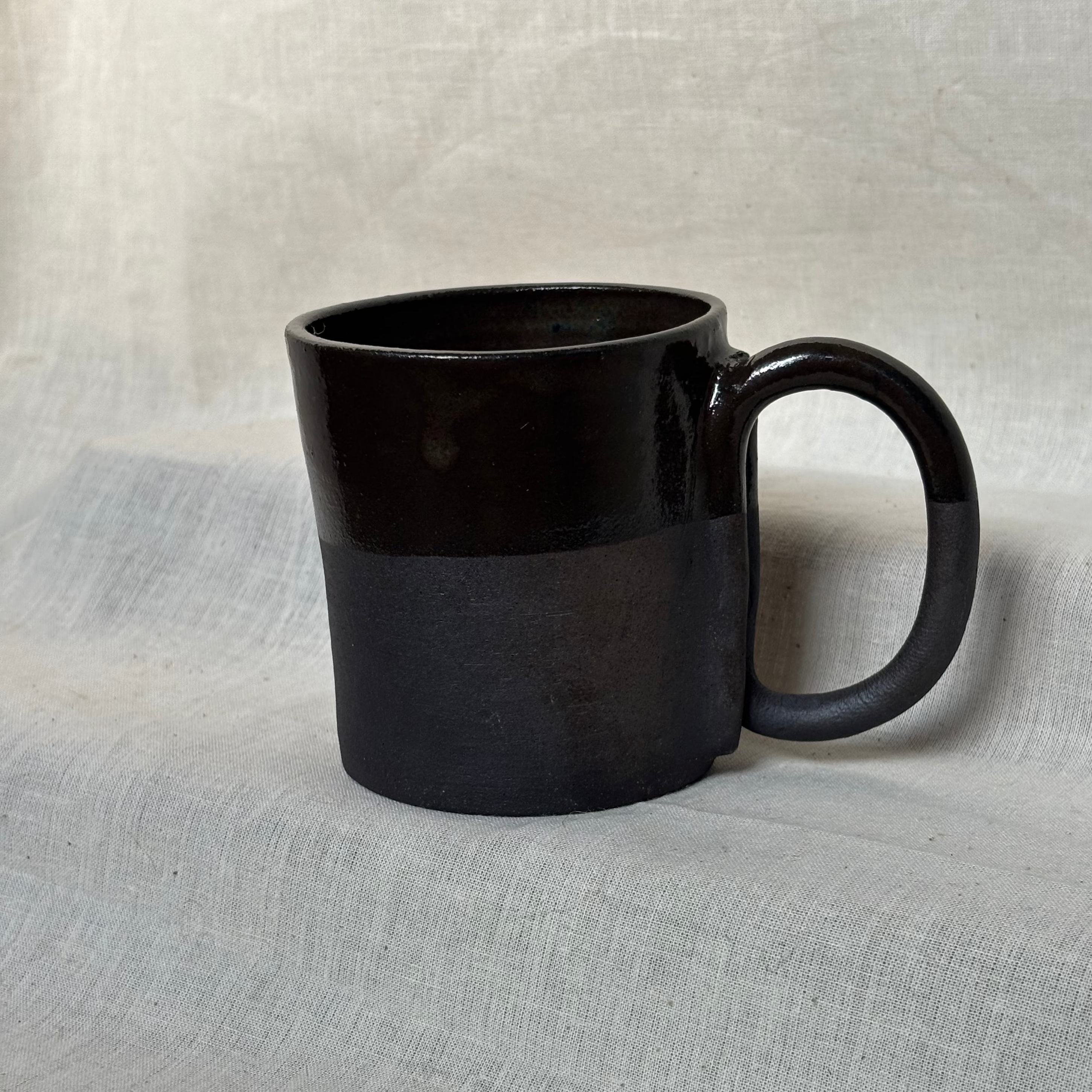 Black ceramic mug glazed half on the outside
